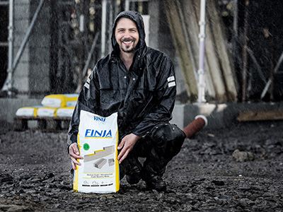 Björn, från serien Björn Bygger Bo, visar upp Finjas fuktsäkra plastsäck i regnigt väder. 